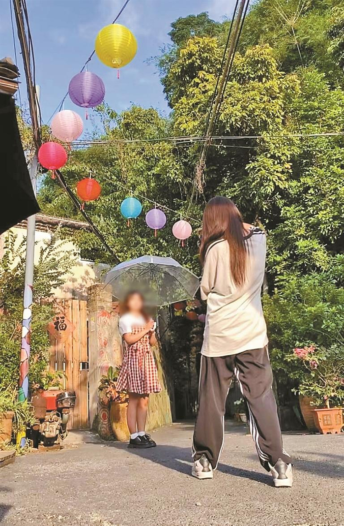 ▲陪拍师“今天要干嘛”（网名）在给顾客拍照。 受访者供图