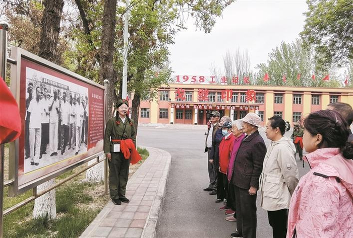     游客在石河子戈壁印象文化和旅游园内聆听讲解员介绍石河子八一棉纺织厂建设发展史（资料图片）。    兵团日报常驻记者  李秀  摄
