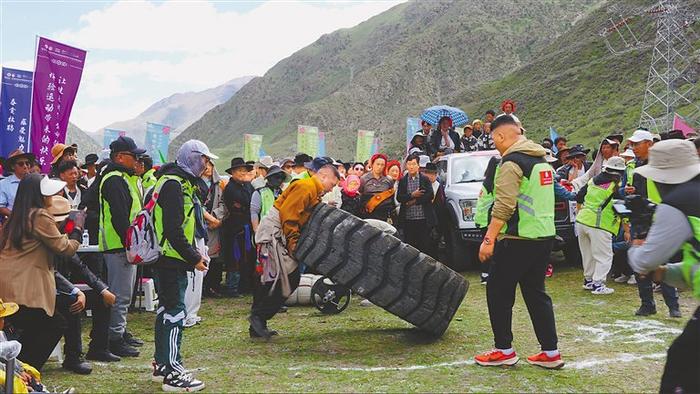 图为村民参加推大型轮胎比赛。