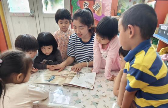 图源：海报新闻。幼儿园老师正带着孩子们阅读绘本