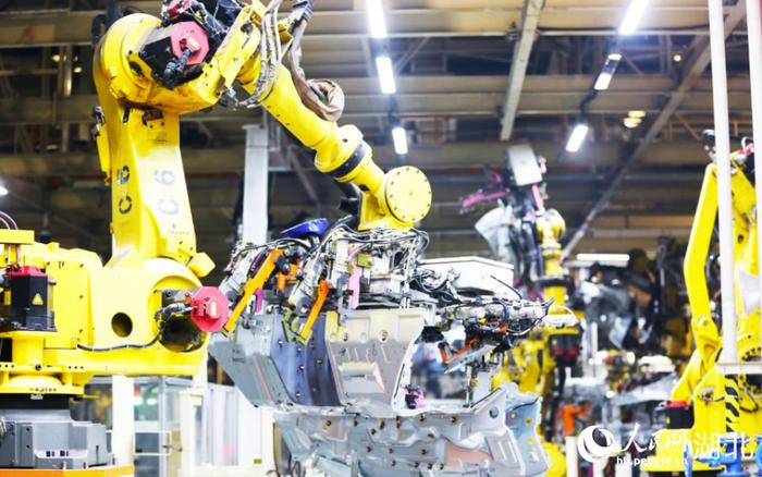 一台台挥舞长臂、收放自如的机器人正在进行焊接工作。人民网记者 王郭骥摄