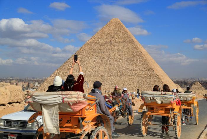 1月24日，游客乘马车游览埃及吉萨金字塔景区。 新华社记者 隋先凯 摄 