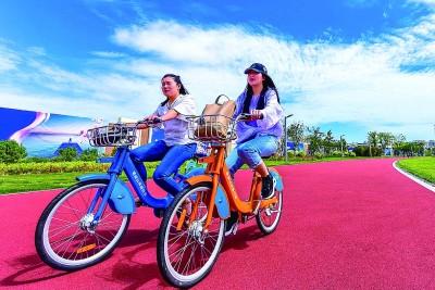 市民骑着共享单车在荣成市樱花湖体育公园畅游。吴建波摄/光明图片