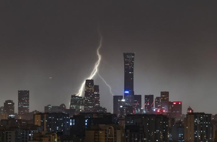 6月13日，从北京西四环眺望国贸CBD，一道闪电划过城市夜空。  新京报记者 浦峰 摄