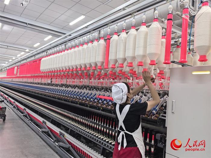 纺纱厂细纱机挡车工在操作中。人民网记者 陈新辉摄
