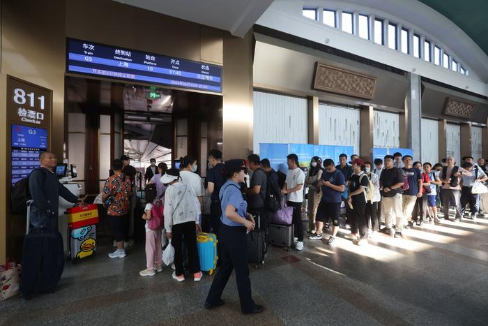 6月15日，北京站，京沪高铁G3次列车旅客在检票口排队检票。  新京报记者 王贵彬 摄