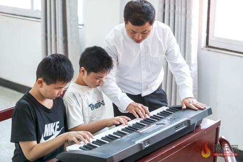 潘家贺在教孩子弹琴