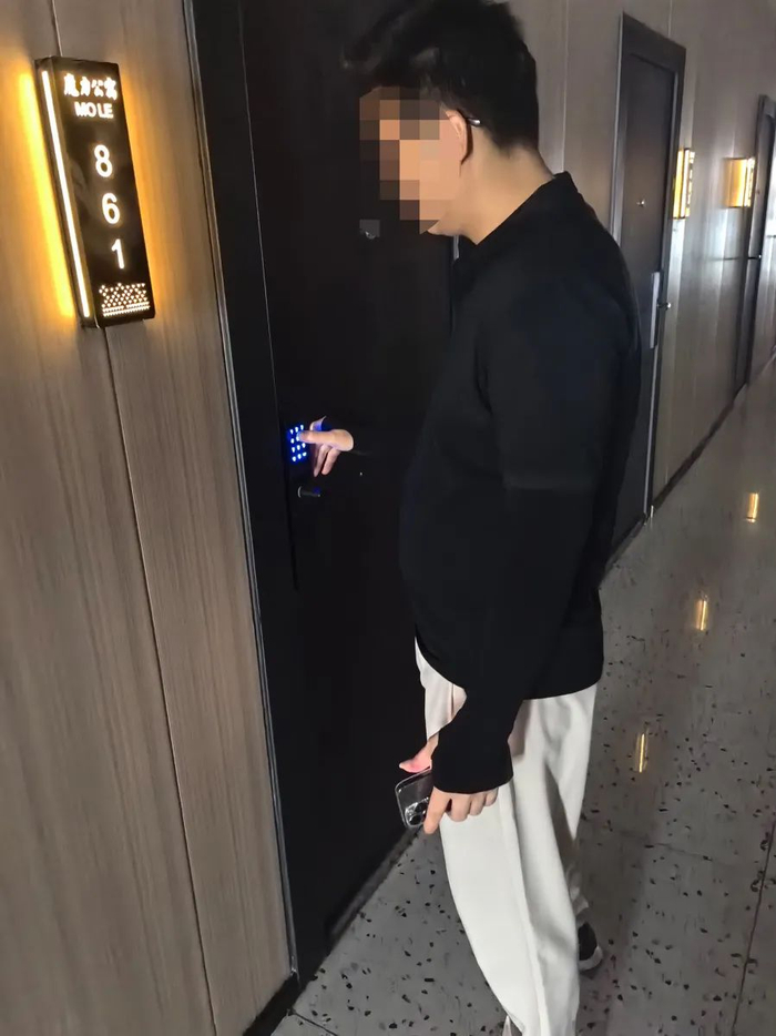 △房产中介肖某正在带记者看“魔力公寓”内的空置房，他能熟练地输入密码解开密码锁。