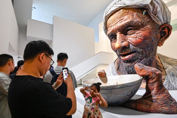▲6月16日，四川美术学院美术馆，高7米、宽5米的巨型雕塑《父亲》前人潮涌动。记者 齐岚森 摄