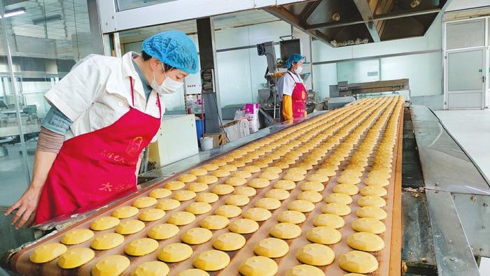 山西鑫炳记食业股份有限公司生产车间里，工作人员正在制作太谷饼。孙泰雁摄