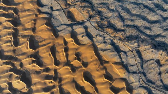 位于宁夏中卫市沙坡头腾格里沙漠边缘的治沙林带与沙漠交汇处（2023年9月6日摄，无人机照片）。新华社记者 王鹏 摄