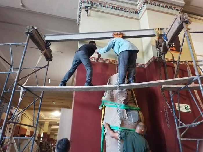 工作人员架起龙门架，准备将石雕拆下运输。（受访者供图）