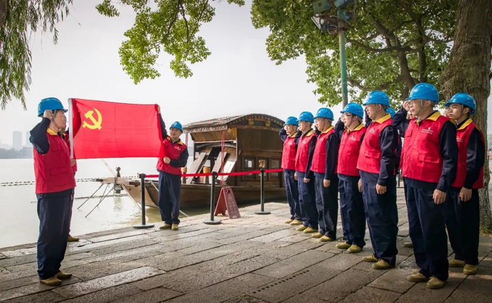 ▲国家电网浙江电力（嘉兴）红船共产党员服务队在嘉兴南湖红船旁面向党旗庄严宣誓