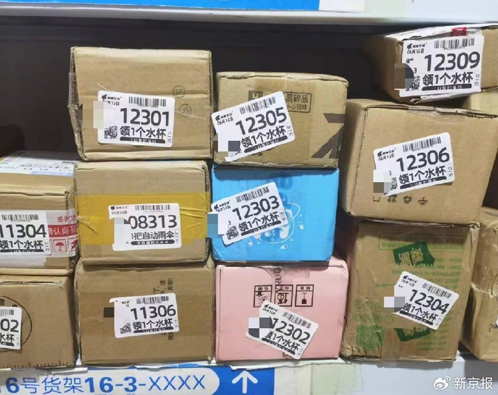 河南郑州某兔喜生活快递驿站，大多快递上贴着的取件码单页，都印有“领水杯”“领雨伞”的广告。 新京报记者 程亚龙 摄