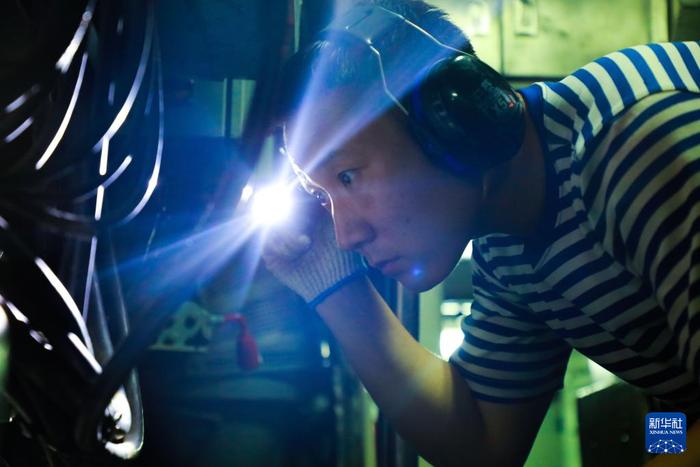   海军某潜艇支队任务潜艇组织艇员在舱底进行装备线路检修（资料照片）。新华社发（茆琳摄）
