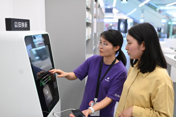 2024年5月13日,重庆市沙坪坝区融创茂商场,市民使用手机回收机器人