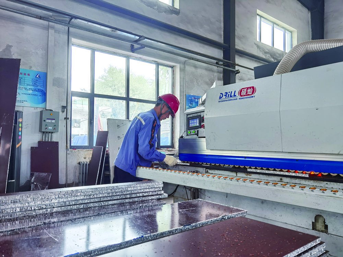     职工正在切割全铝家具板材。王红 摄