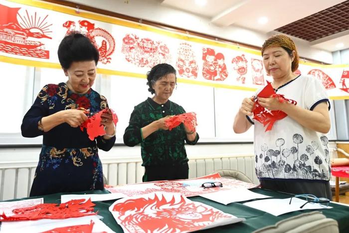 近日，宁夏银川市金凤区长城花园社区居民在创作剪纸作品。新华社记者 毛竹 摄