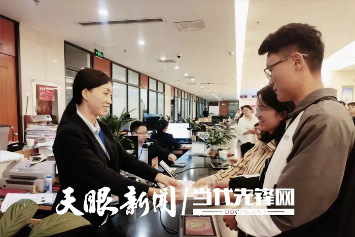 图为大方县政务服务中心工作人员为群众办理残疾证。