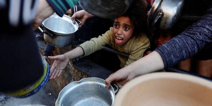 加沙饥民在等待食物配给。图/《华尔街日报》