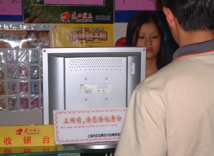 图为2002年，《互联网上网服务营业场所管理条例》施行，上海某网吧柜台上写着“上网前，请您登记身份”。（视觉中国）