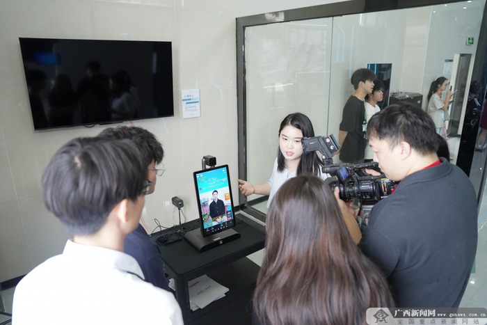 吴宏妮老师向学生和媒体团介绍AI数字人直播设备使用方法。记者 古秀芳 摄