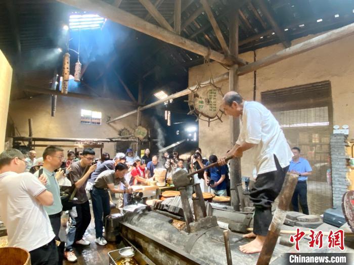 富溪村的百年山茶油作坊内，72岁的游信玉抡起几十斤重的石锤，一锤一锤敲打着，将楔子打进榨槽。中新网记者 叶茂 摄