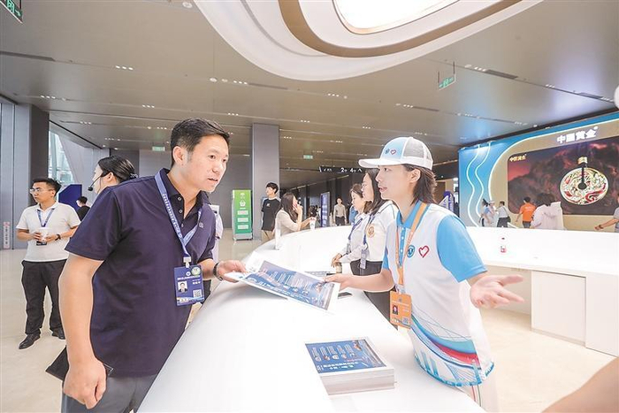     6月17日，服务2024廊坊经洽会的青年志愿者在临空国际会展中心内为中外宾客解答问题。    本报记者 陈童 摄