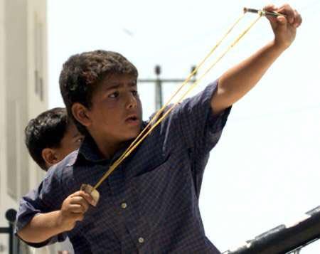   用弹弓攻击以军的巴勒斯坦男孩。图/《巴勒斯坦纪事报》