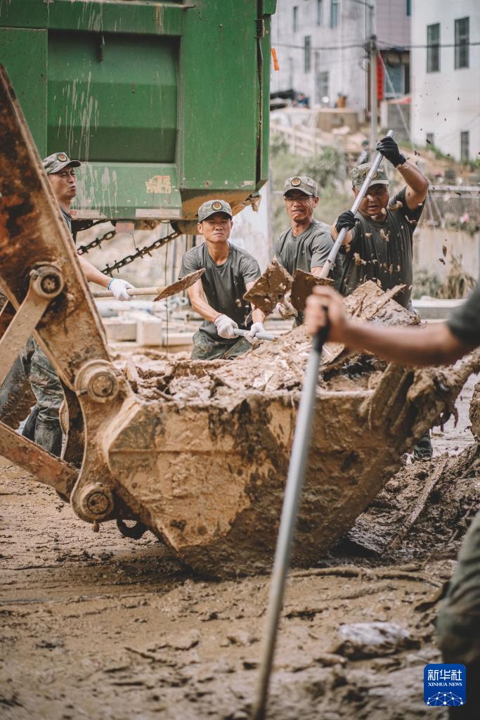 　　6月20日，福建省军区龙岩军分区民兵在武平县岩前镇清理淤泥。新华社发（李伟君 摄）