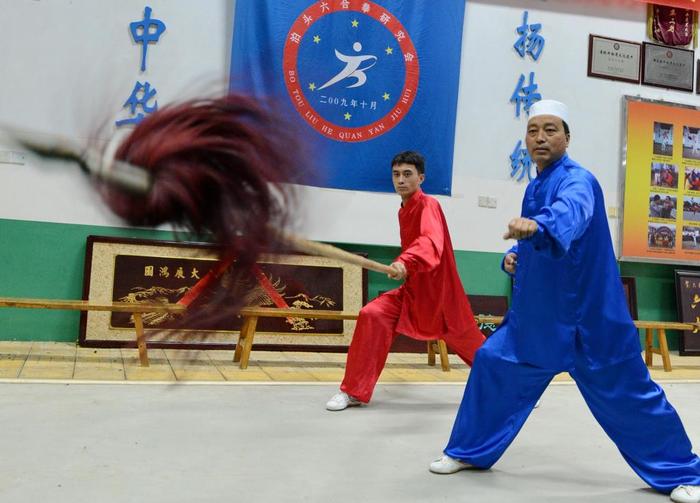 2014年10月22日，石同鼎（右）及其弟子在六合武馆内练武。
