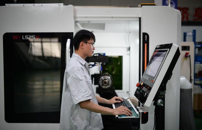 员工在位于广东省佛山市的原点智能技术有限公司车间操作数控机床（5月16日摄）。新华社记者 李任滋 摄