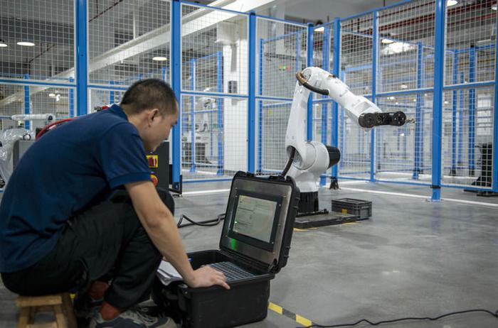 在广东拓斯达科技股份有限公司，工作人员对一台工业机器人进行绝对定位精度的校准（5月17日摄）。新华社记者 徐嘉懿 摄