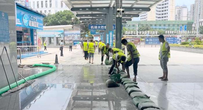 6月21日桂林站，中铁十二局的工作人员在出站口堆积沙袋。吴欣宇/摄