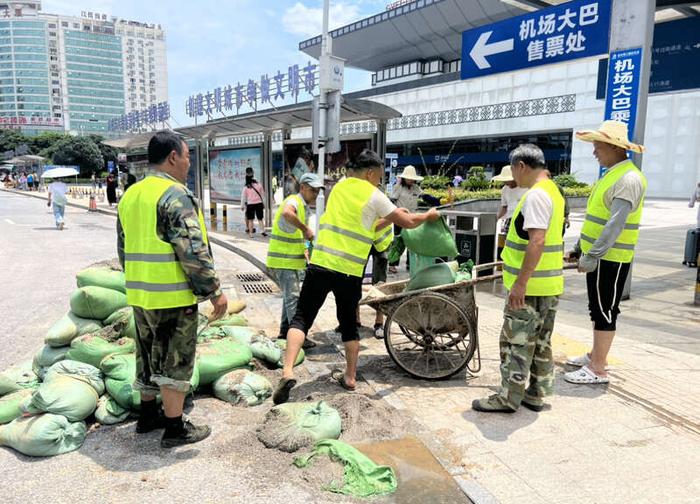 6月21日桂林站，中铁十二局的工作人员正在运送沙袋至出站口。吴欣宇/摄