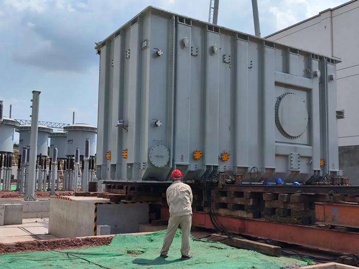中国外运工作人员将重达345吨的变压器卸车就位