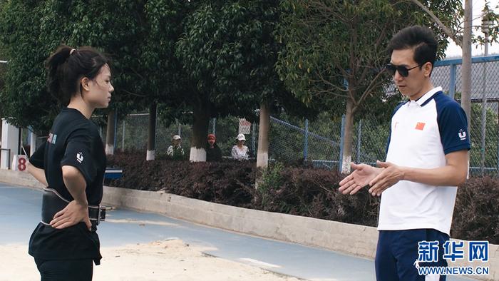   教练杨帆（右）正在为江南（左）纠正训练动作（资料图）。新华网发（云南师范大学 供图）