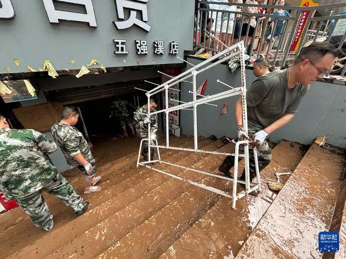   6月23日，沅陵县五强溪镇当地政府组织力量帮助沿街商铺搬运被洪水浸泡的物品（手机照片）。新华社记者 余春生 摄