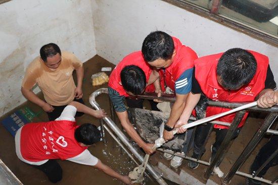 6月22日，中建八局青年救灾突击队在临江苑小区抽排地下车库积水。王宝兴/摄