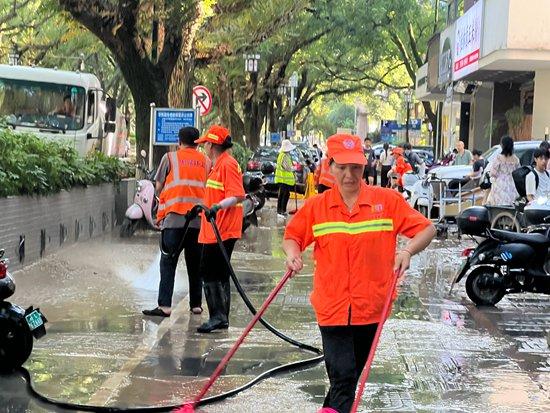 6月23日，环卫工人在滨江路清扫人行道。吴欣宇/摄