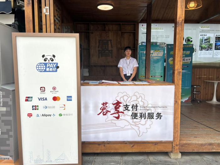 在宽窄巷子入口处的志愿者服务站旁边，立着一块醒目的标示牌，上面写明支持的支付方式。姜樊/摄
