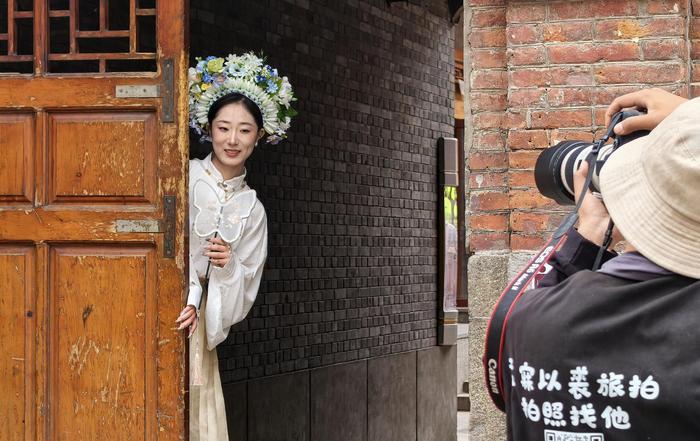 游客在中华巴洛克历史文化街区拍簪花照