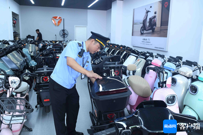 执法人员对电动自行车进行检查。记者 蒙健 摄