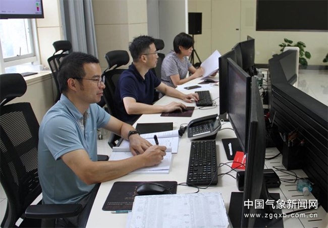 6月27日，武汉中心气象台值班人员分析研判强降水形势。童奇 摄影