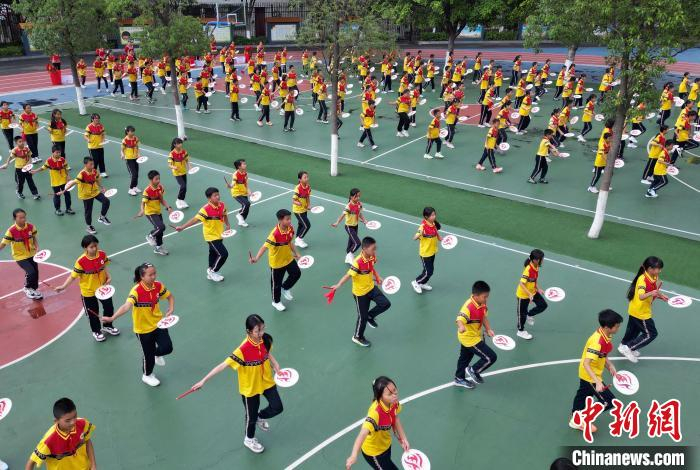 在攀枝花仁和区平地镇中心学校，每天大课间，孩子们在操场上跳起由非遗“羊皮鼓舞”改编而来的课间操《彝风鼓韵》。　王磊 摄
