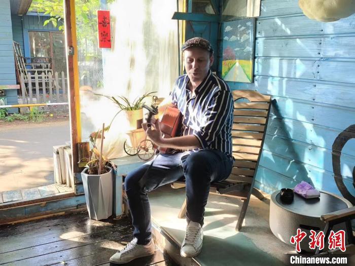6月13日，吉米在海口一家咖啡厅表演吉他弹唱。　中新社记者 张茜翼 摄