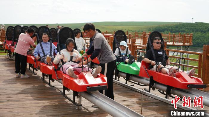 图为游客正在奥洛契庄园体验旅游项目，工作人员正在检查安全带。胡瀛摄