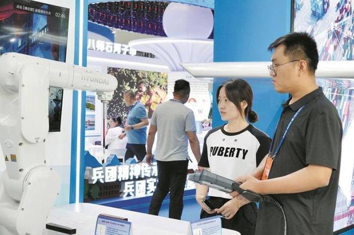 6月29日，在第八届中国—亚欧博览会上，十二师展区工作人员向观众展示工业机器人。兵团日报全媒体记者 邵明辉 摄