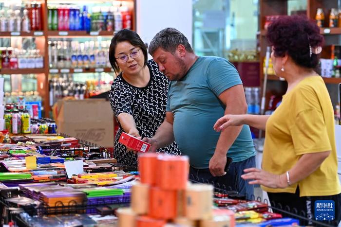   在新疆塔城巴克图中哈边民互市丝路文化商品城，一位哈萨克斯坦的游客在选购商品（2023年7月22日摄）。新华社记者 丁磊 摄