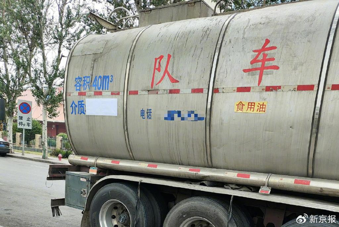 一辆等待进厂装载食用油的罐车，罐体介质信息被白纸遮盖住，旁边重新张贴了一张写有“食用油”字样的纸条。 新京报记者 韩福涛 摄
